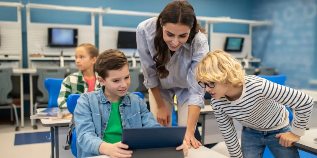 Insegnante aiuta i propri studenti con il tablet