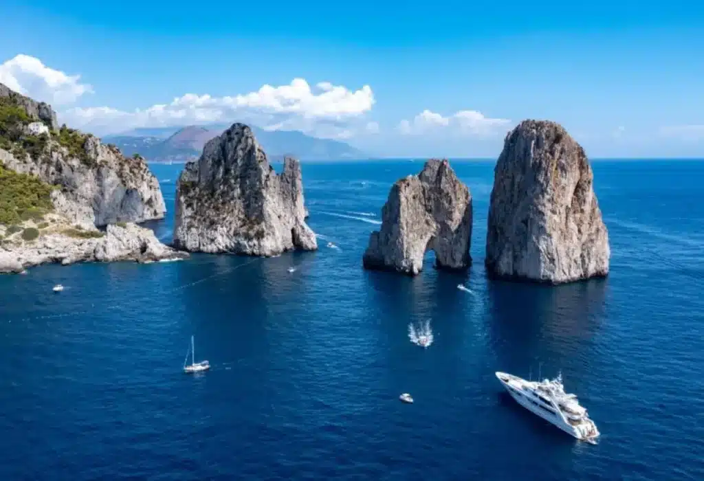 I Faraglioni di Capri nel Golfo di Napoli, con imbarcazioni turistiche che navigano