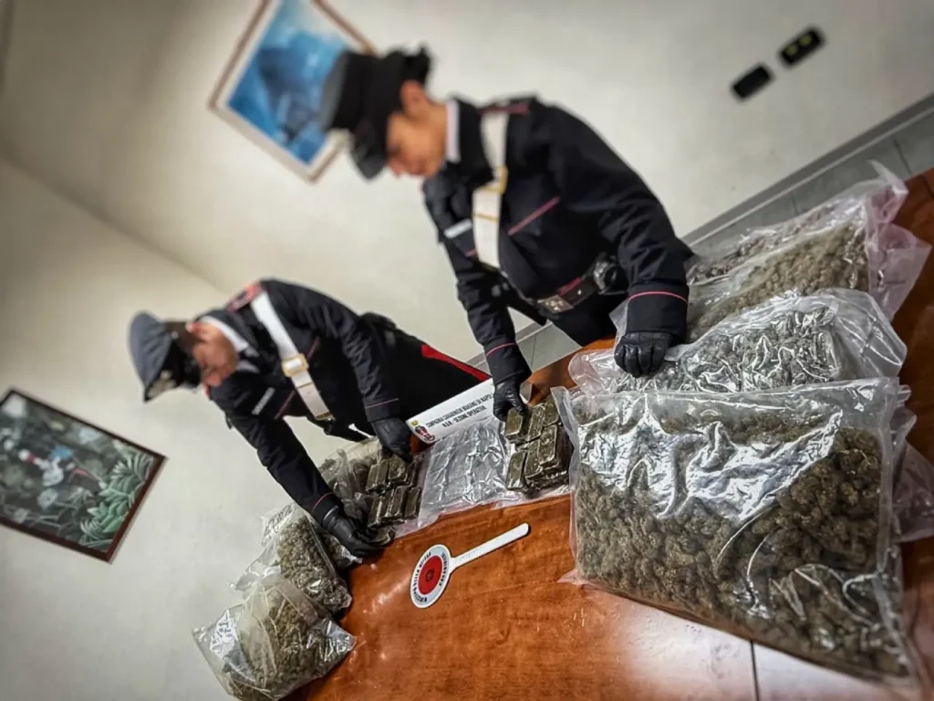 Carabinieri mostrano ingenti quantitativi di droga sequestrata durante un’operazione antidroga a Napoli.
