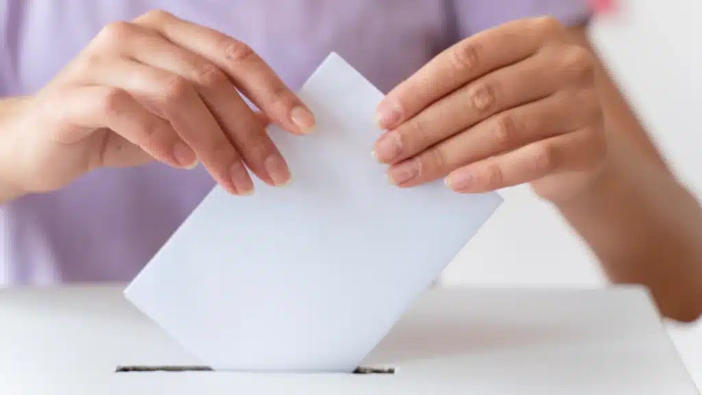Persona che mette il suo voto in una casella - immagine di repertorio