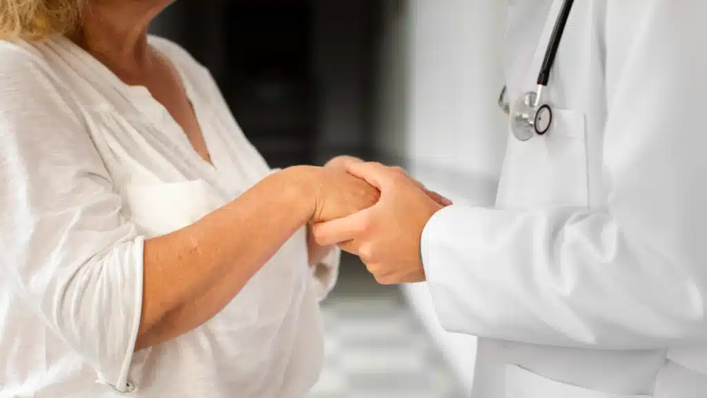 Mani del medico che tengono le mani della donna