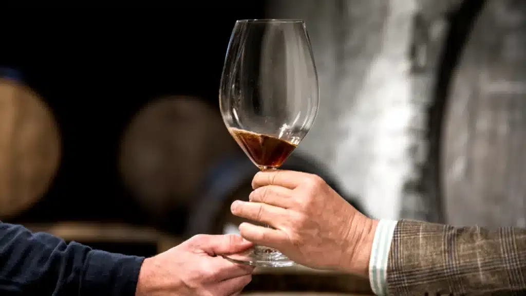 Mani di vista laterale che tengono il bicchiere di vino - immagine di repertorio