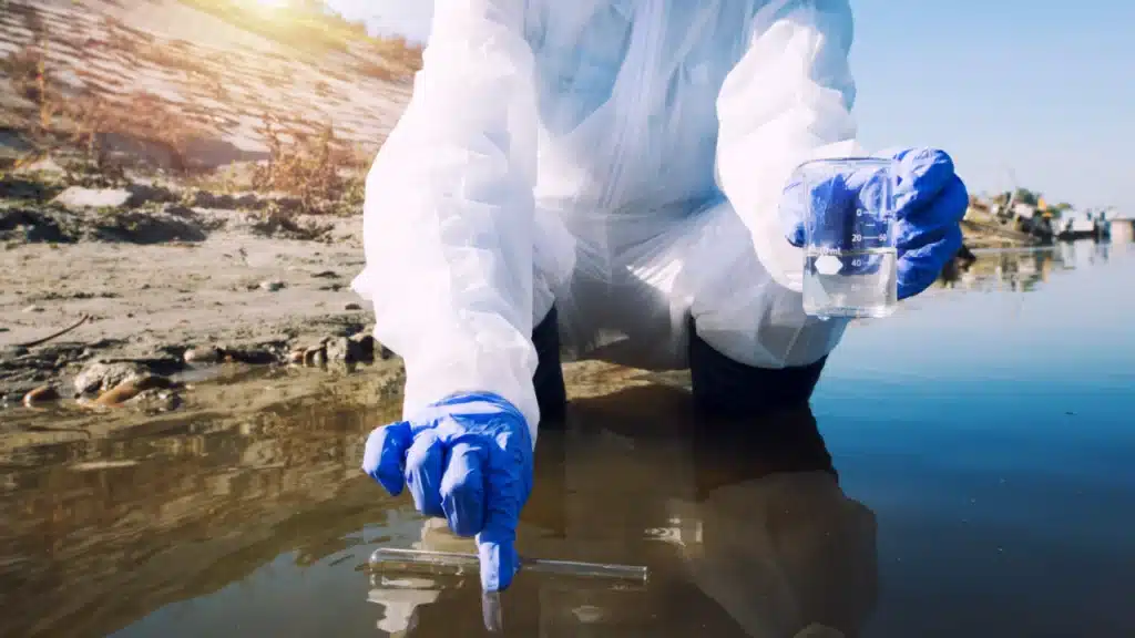 Ecologo che preleva campioni di acqua con provetta - immagine di repertorio